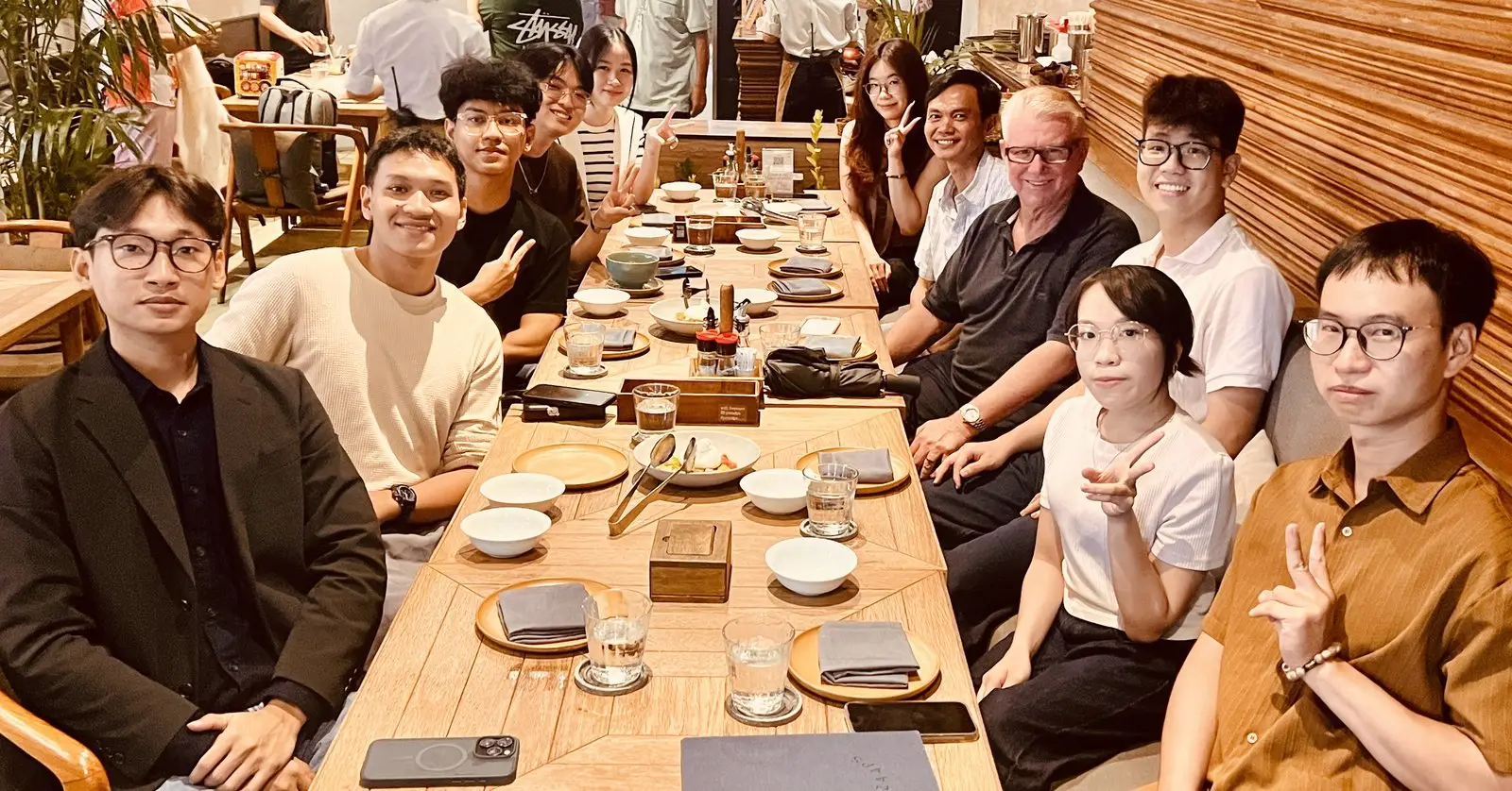 Komosion's Ho Chi Minh City team with John O'Neill around a long restaurant table